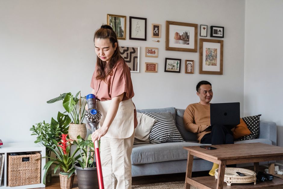 散らかった部屋でため息をつく女性