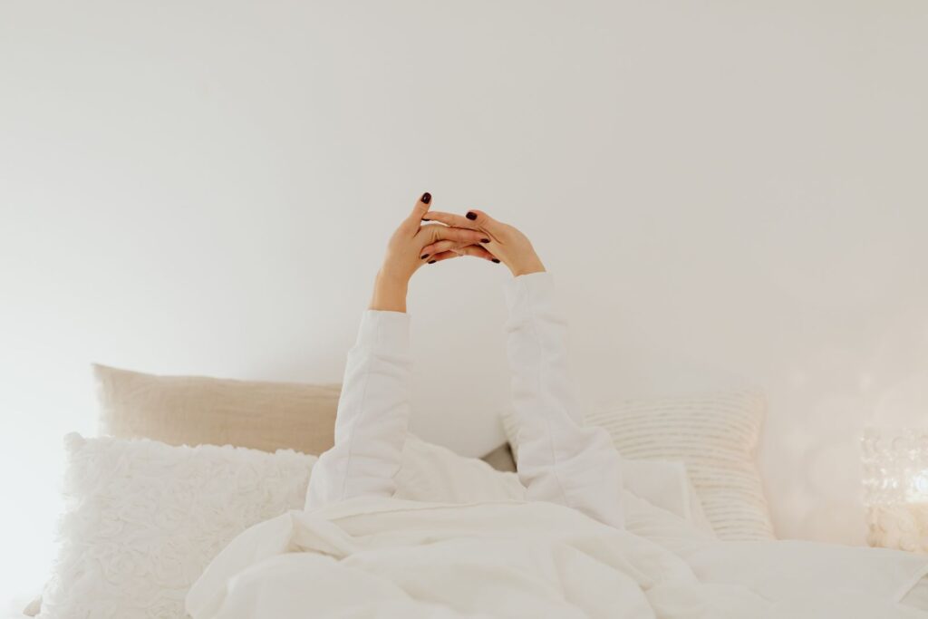 朝起きてすぐスマホを見るに悩む女性のイメージ